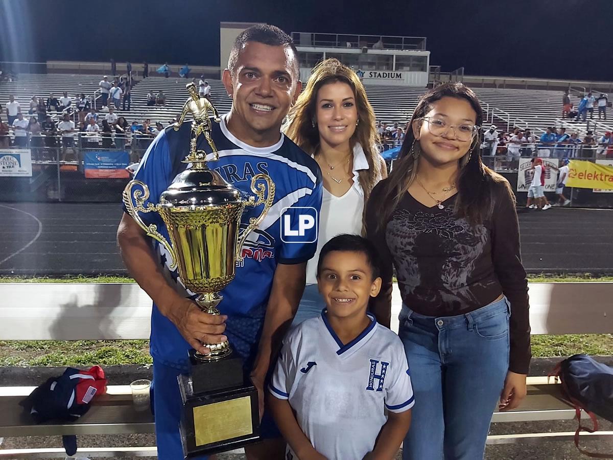 Amado Guevara posando con el trofeo y su familia.