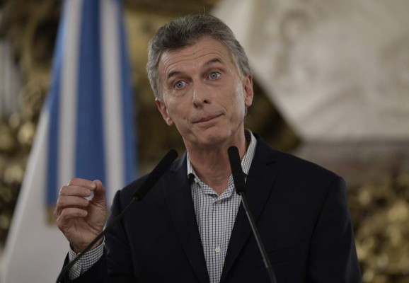 Argentina's President Mauricio Macri gestures during a press conference at the Casa Rosada in Buenos Aires on February 16, 2017.Among other topics he mentioned, Macri announced that he had ordered the negotiation of a new deal to settle debts incurred by the postal service in a period when it was controlled by his father's business, which triggered a scandal due to a suspected conflict of interest. / AFP PHOTO / JUAN MABROMATA