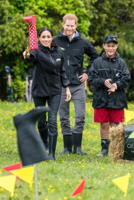 Britain's Meghan, Duchess of Sussex participates in a gumboot throwing competition with Prince Harry after unveiling a plaque dedicating 20 hectares of native bush to the Queen's Commonwealth Canopy project at The North Shore Riding Club in Auckland on October 30, 2018. - Meghan Markle displayed an unexpected talent for 'welly wanging' in Auckland on October 30, gaining bragging rights over husband Prince Harry after they competed in the oddball New Zealand sport. (Photo by STR / POOL / AFP)