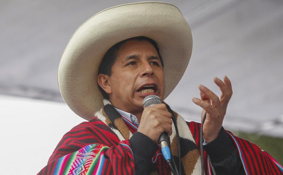 Pedro Castillo, vestido con atuendo andino típico, habla durante una manifestación masiva que pide estabilidad política y económica.