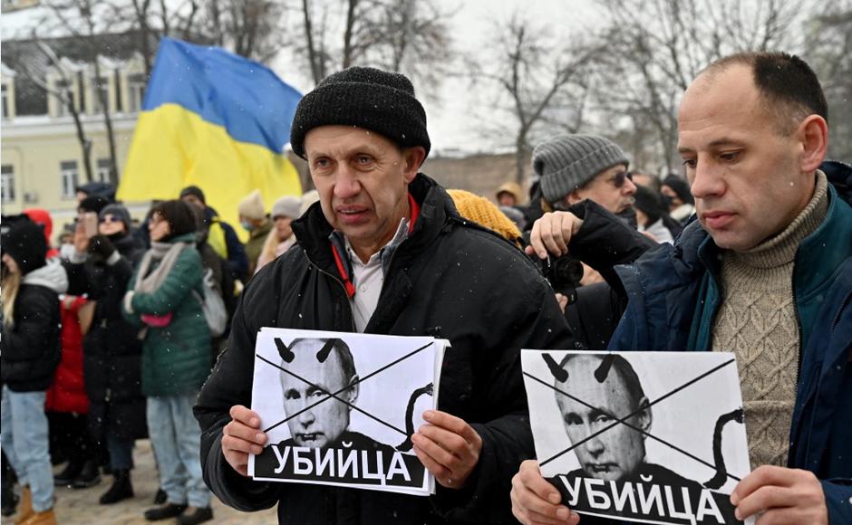 Los manifestantes sostienen pancartas que representan al presidente ruso Vladimir Putin.